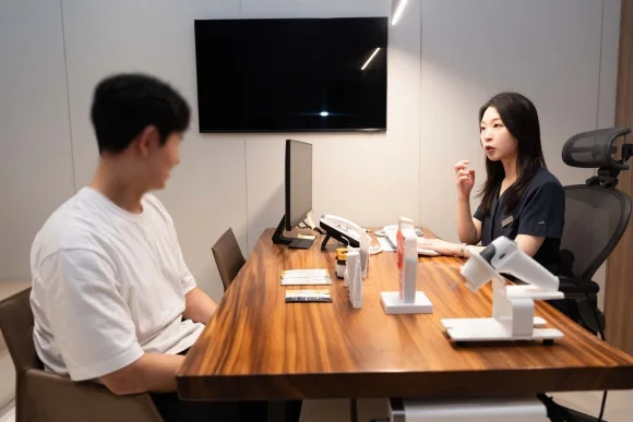 목 이물감이 낫지 않는 이유|의료진과 환자가 마주 앉아 상담하는 모습