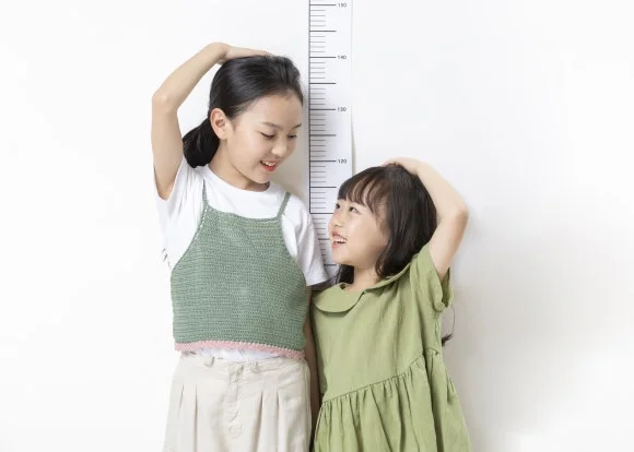 어린이 코막힘|키를 재며 즐거워하는 두 어린이의 모습